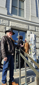 Phillip B Gottfredson on the steps of the Utah State Capitol pointing at Gary Lee Prices Statue of Responsibility